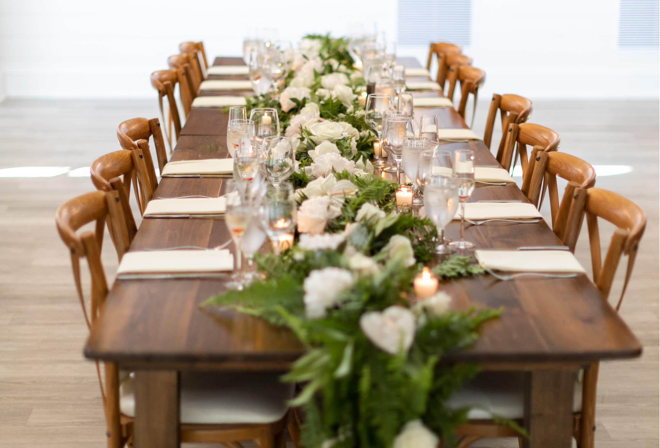 a long dining table set with flowers, candles, and wine glasses