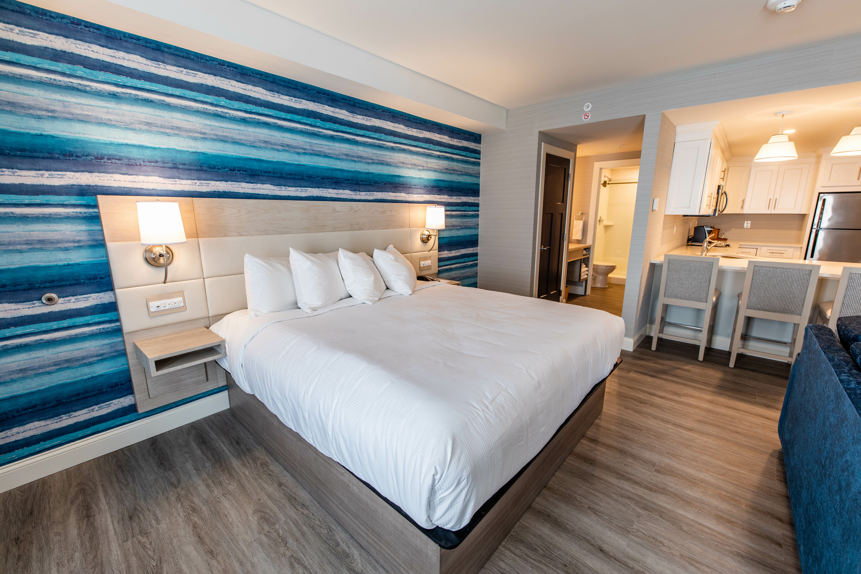 A suite with a king-sized bed, kitchenette, and sofa.